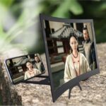 Black optical screen magnifier with phone behind the lens; phone not included